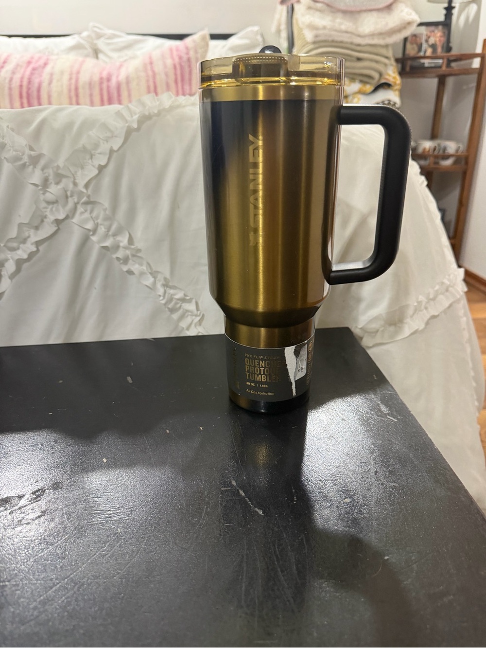 40 ounce gold and black colored Stanley Tumblr with flip straw lid